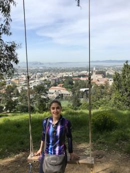 Maria poses for a photo in the hills of Berkeley with a view of the San Francisco Bay Area