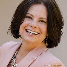 Instructor Rosemary Hossenlopp smiling at the camera wearing a pink blazer