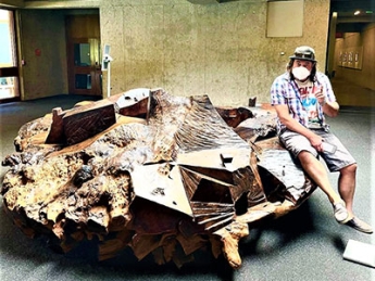 Post-Bacc Visual Arts graduate Jeff Maylath next to “The Planet” by JB Blunk (Oakland Museum of California)