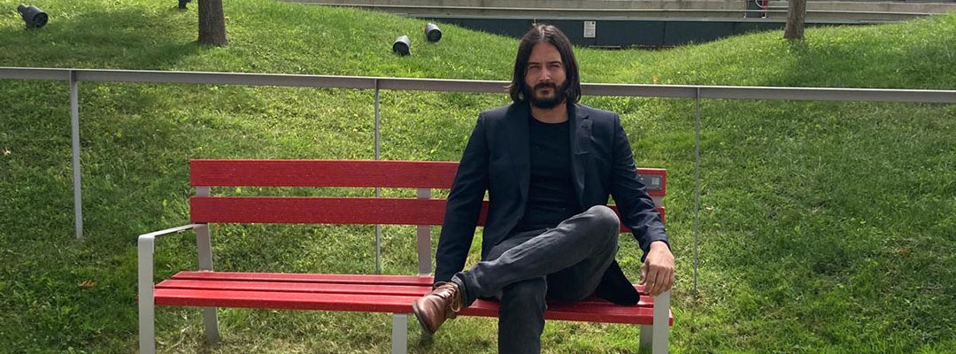 Photo of Dany Bonaventura sitting on a red fence