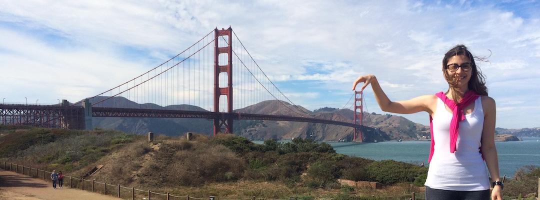 Graduate Maria Paula poses playfully in front of the Golden Gate bridge