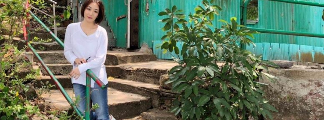 Wenhan Lu sitting on the steps of her home