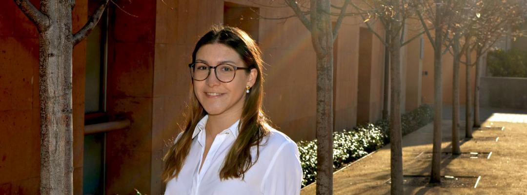 UX design professional Macarena Muniz standing in a shaft of light