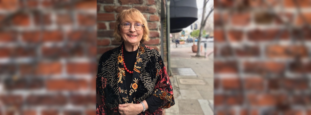 Accounting certificate instructor Patricia Egan stands outside in front of a brick wall 