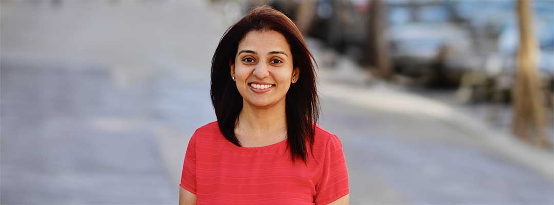 Photo of Swapna Savant wearing red shirt standing on a sidewalk