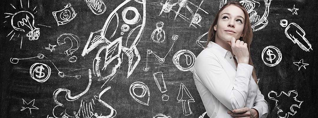 Business icons on blackboard with white young female professional standing in front