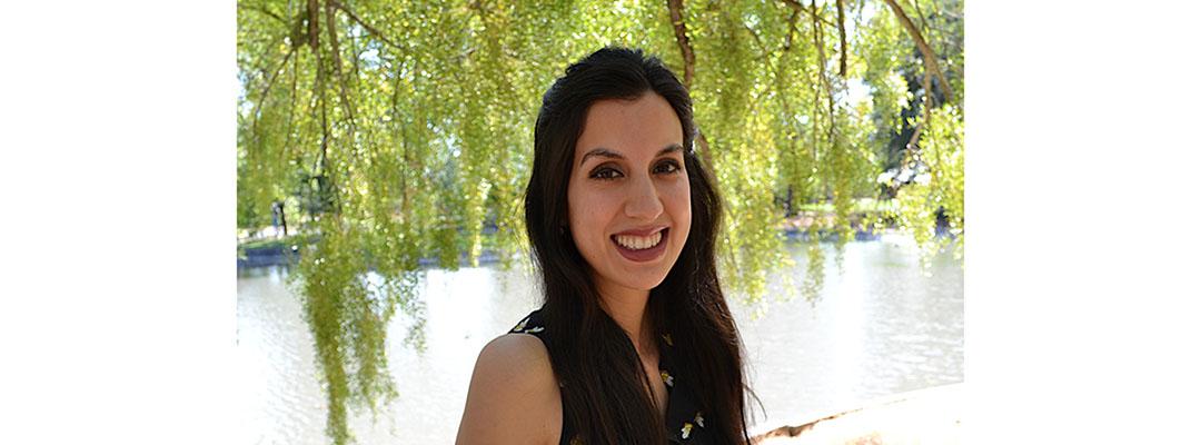 CLS Prep Program graduate Ester Fernandez standing by water, under a tree