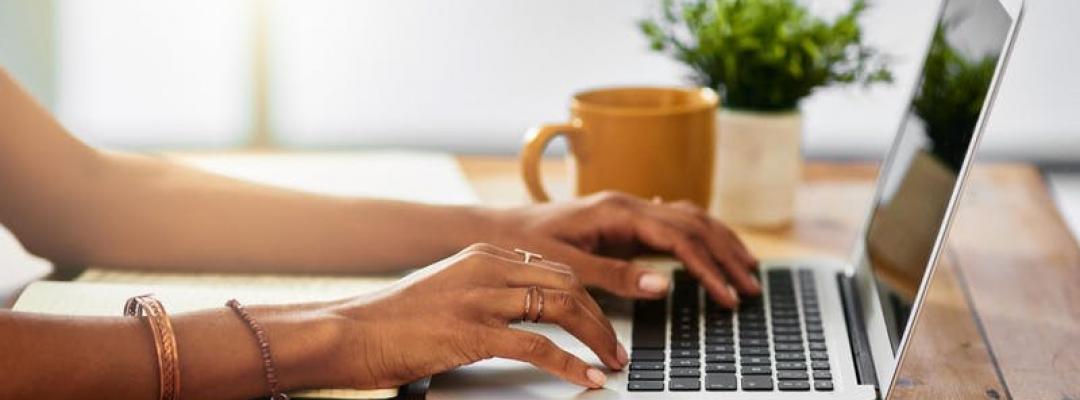 Photo of woman's hands typing on a keyboard