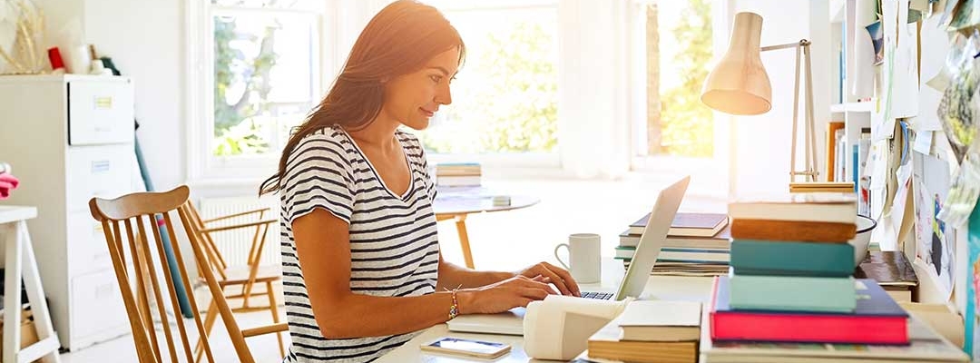 Woman typing on laptop in apartment room