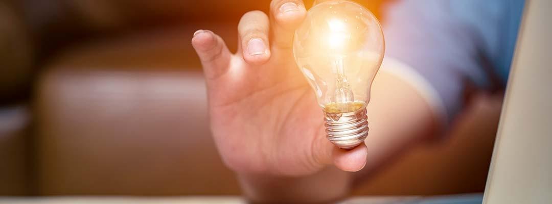 man holding lightbulb in foreground