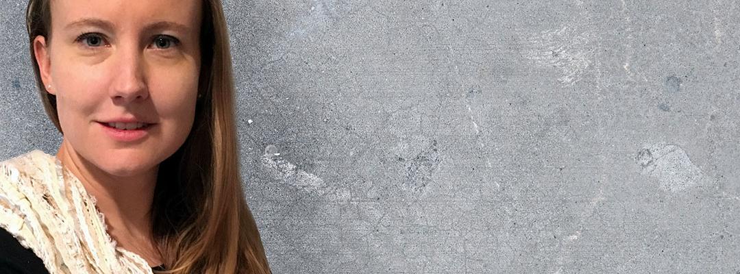 Sarah Sprague standing in front of a concrete wall