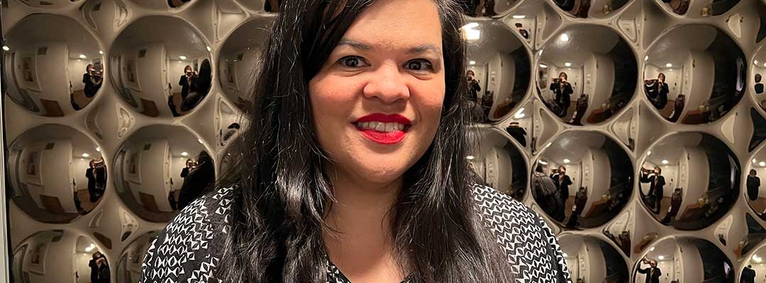 Shannon MIlar standing in front of numerous circle mirrors