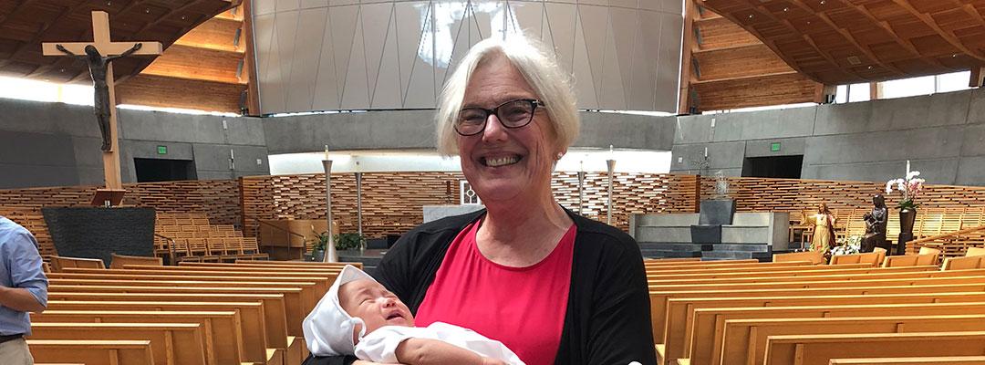 Photograph of Alcohol and Drug Abuse Studies graduate Therese Becker holding her grandson at his baptism