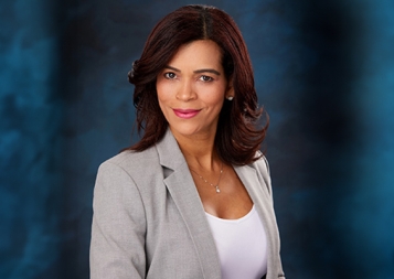 Headshot of Alis Vazquez in front of a blue background