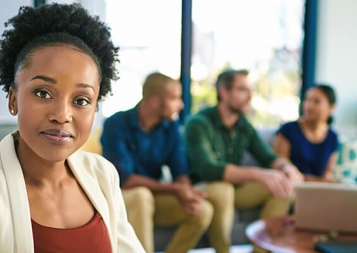 Businesswoman in a meeting looks at the camera