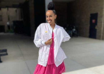 Brhan Eskinder wearing her white coat in front of a school building