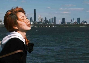 Photo of Dan Zhu smiling in front of San Francisco skyline