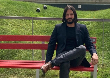 Photo of Dany Bonaventura sitting on a red fence