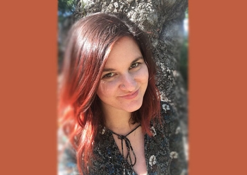 Photo of Holly Smith standing in front of a tree 