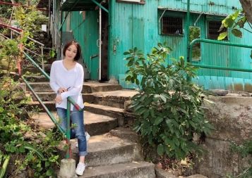 Wenhan Lu sitting on the steps of her home