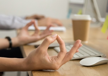 Hands of employee at the work place in meditative posture