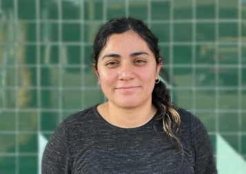 Photo of Lucía Moreno Nava in front of a green tile wall