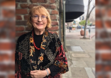 Accounting certificate instructor Patricia Egan stands outside in front of a brick wall 