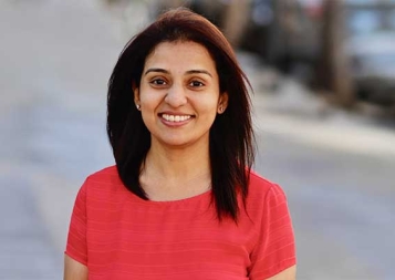 Photo of Swapna Savant wearing red shirt standing on a sidewalk