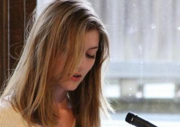 Professional Writing Community Impact Scholarship winner Adelle Brunstad reading her work at an event. Photo.