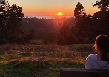 Aliona Margulis sitting on park bench in Berkeley watching the sunset