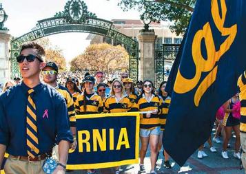 UC Berkeley students holding Cal floag and banner in a parade