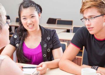 Photo of educational consultant working with two high school students