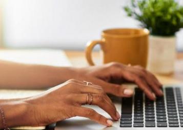 Photo of woman's hands typing on a keyboard