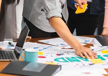 Photo of group of marketing professionals working on branding documents and sticky notes