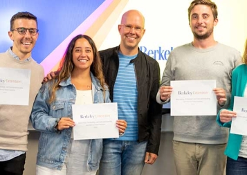 Graham Quigley (center) standing with graduates of a custom program