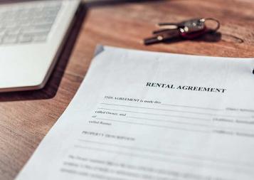 Photo of rental agreement paperwork next to a laptop