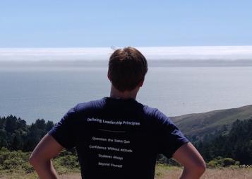 BHGAP student Hugo wears his Haas School of Business t-shirt and looks out over a view of Berkeley