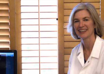 Photo of Jennifer Doudna next to a computer screen showing genome