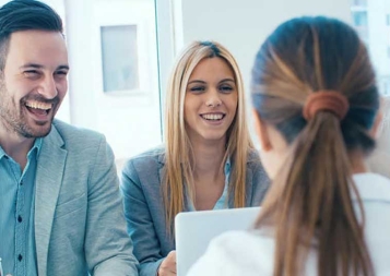 Working professionals smiling while seated in a small group