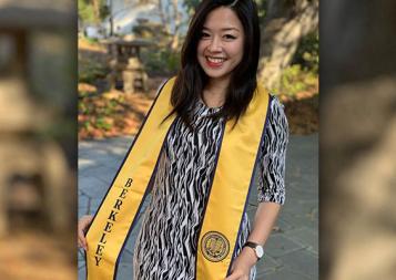 Jolin Wu wearing a Berkeley graduation scarf standing in front of some trees