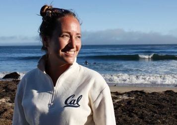 Photo of Nicole Schreyer at the beach wearing a white UC Berkeley sweatshirt