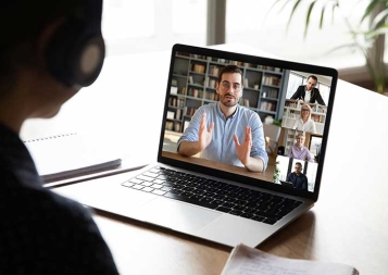 Photo of team members working on laptop through Zoom