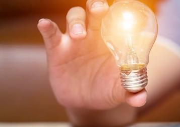 man holding lightbulb in foreground