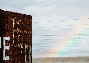 Stock photo of Greek refugee center with "hope" graffiti and rainbow