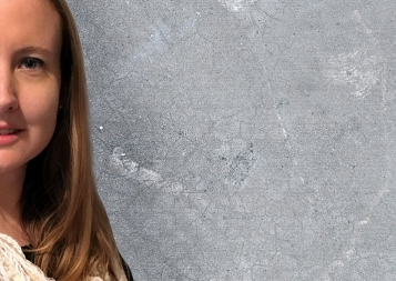 Sarah Sprague standing in front of a concrete wall