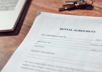 Photo of rental agreement paperwork next to a laptop