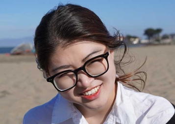 Photo of Sibble Zhang at the beach below the Golden Gate Bridge