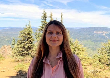 Photo of Tetiana Pairman in front of a forest and mountain background