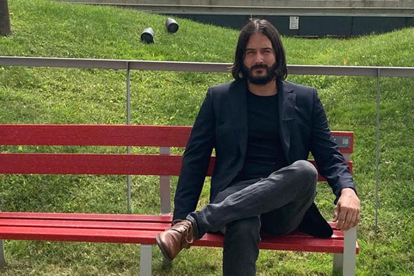 Photo of Dany Bonaventura sitting on a red fence