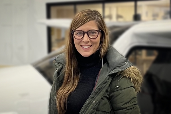 Professional Sequence in Editing graduate Megan Rupert, in front of small aircraft